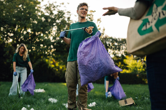 Group of people volunteers collecting rubbish in park