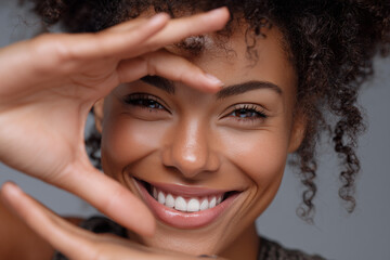 Obraz premium Smiling woman framing face with hands