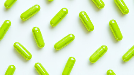 Flat lay composition of vibrant green toddler-sized capsules on a clean white background. High-resolution image perfect for pharmaceutical, healthcare, or pediatric-themed visuals