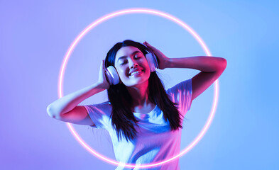 Favorite music concept. Asian woman in headphones with neon circle