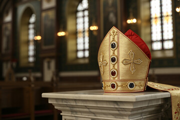 sacred golden mitre positioned on marble pedestal, elaborate ecclesiastical craftsmanship