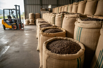 burlap hemp sacks filled with coffee beans in industrial warehouse, sustainable packaging solutions for bulk storage