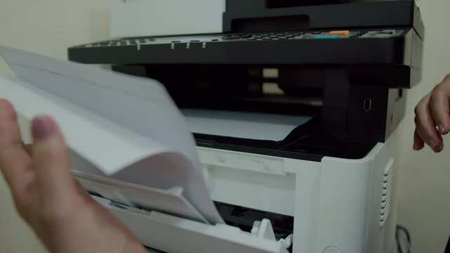 Person inserting paper into multifunction printer tray