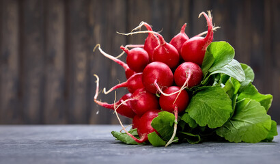 Bunch radish at background old board in rustic style. Close-up side view. Harvest fresh organic vegetables.