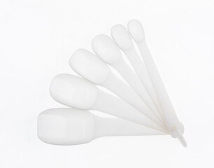 folding white plastic spoons isolated on white background