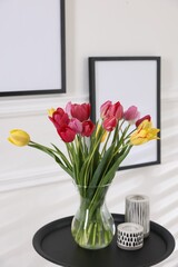 Bouquet of beautiful tulips and decor on table indoors