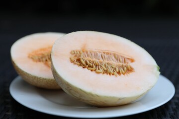 Halves of juicy melon on wicker table, closeup