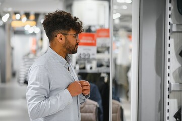 Elegant arab man trying on clothes in a retail store