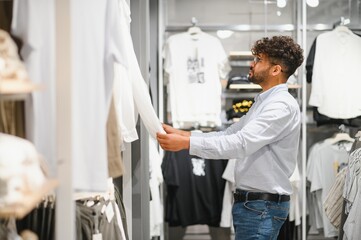 Elegant arab man choosing clothes in fashion store