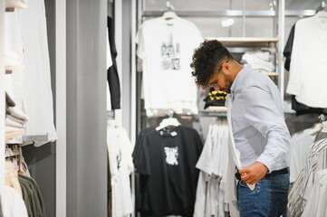 Arab man choosing clothes in fashion store
