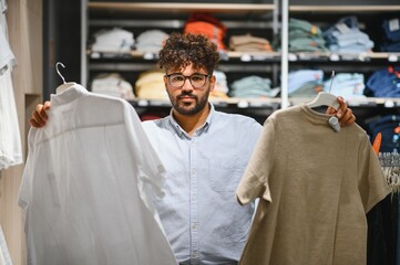 Stylish man choosing clothes in fashion store