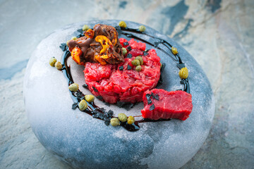 Gourmet beef tartar made of raw beef fillet with capers,  ceshew chocolate and balsamic vinegar...