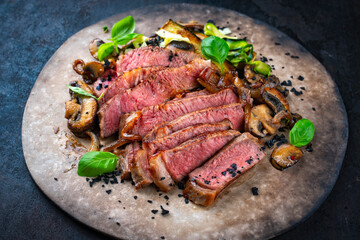Traditional barbecue grass-fed dry aged roast beef steak  with mushrooms and greens served as...