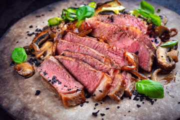 Traditional barbecue grass-fed dry aged roast beef steak  with mushrooms and greens served as...