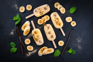 Frozen dessert - homemade banana and vanilla ice lolly popsicle with yogurt and brown sugar offered...