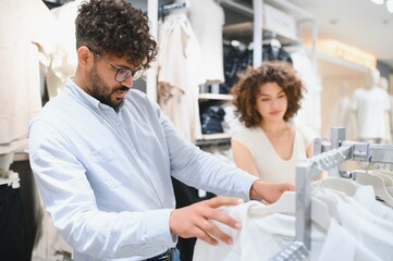 Obraz premium Arab couple choosing clothes in fashion store