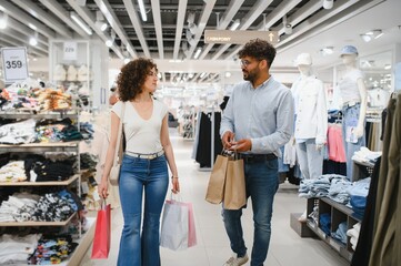 Couple walking in fashion store holding shopping bags
