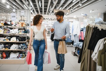 Couple walking in fashion store carrying shopping bags
