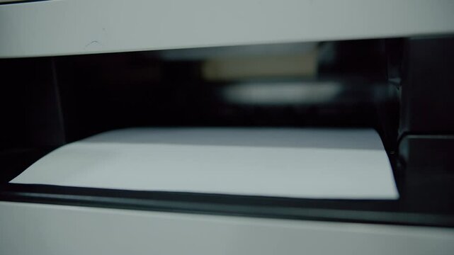 Sheet of paper emerging from laser printer output tray