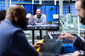 Photovoltaics factory managers visualize floor designs with 3D software on tablet during internet...