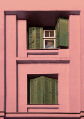 dark green metal window jalousie blind shutter frame with cracks gaps in purple violet color building house home wall exterior background. Belgrade Serbia,