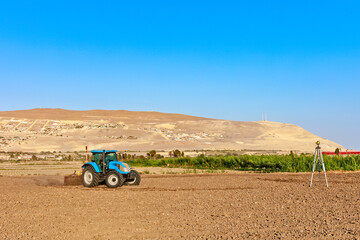 Obraz premium Tractor with soil leveler working in the field
