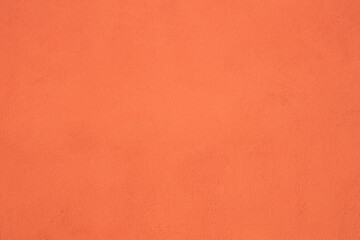 Pale pink colored low contrast Concrete stucco plaster textured background with roughness and irregularities. 2020, 2024, 2021 color trend. peach fuzz Exterior wall fence