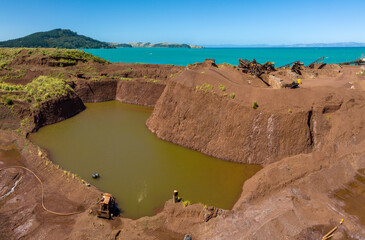 Iron sand mining operation in New Zealand, showing the pit, water, and processing equipment used...