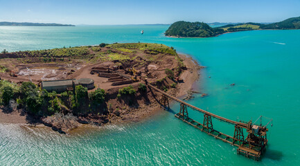 Aerial view of a disused coastal mine and jetty on Karamuramu Island, highlighting industrial...