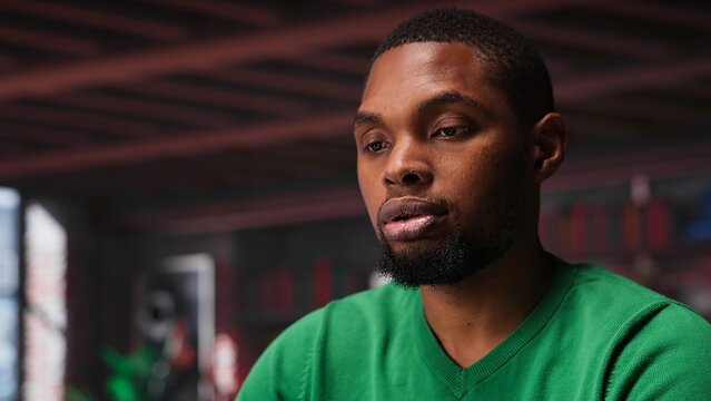 African american freelancer at home office sitting at desk and typing on laptop keyboard, writing down ideas to solve his daily assignments. Remote worker answering inquiries. Camera A.