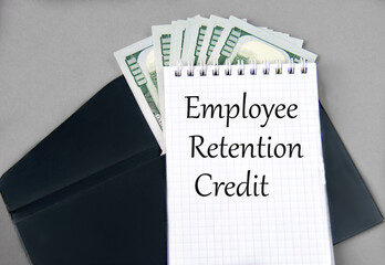EMPLOYEE RETENTION CREDIT - words in a notebook against the background of a black envelope and banknotes