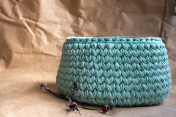 Handcrafted Turquoise Knitted Basket on Rustic Brown Background