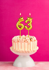 Pink birthday celebration cake with number 63 candle