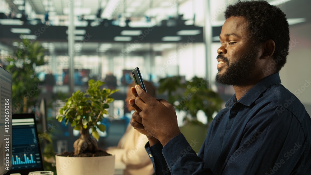 Poster employee in office taking break from checking documents to text friends using smartphone, relaxing. 