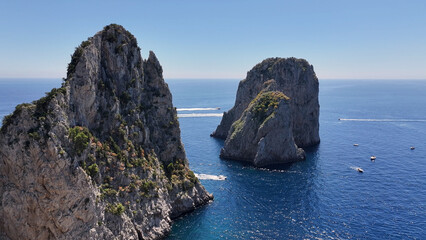 Naklejka premium Faraglioni Of Capri At Naples In Campania Italy. Coastal Landscape. Waterfront Scene. Faraglioni Of Capri At Naples In Campania Italy. Beach Scenery. Paradisiac Seafront. Capri Island Skyline.