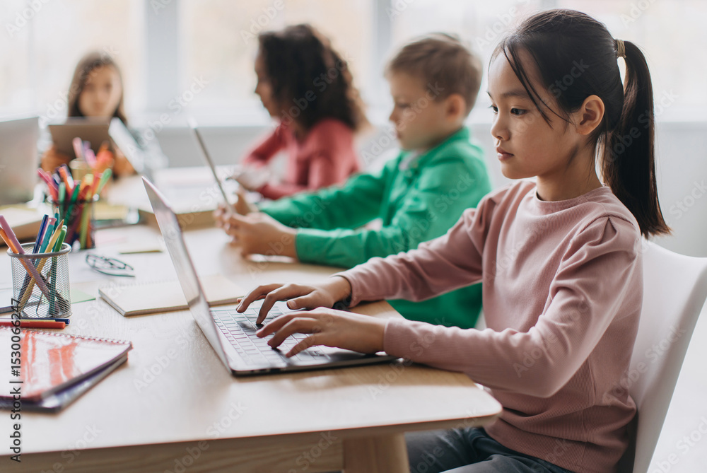 Aufkleber korean little girl using laptop sitting at desk with multiracial classmates in modern classroom indo