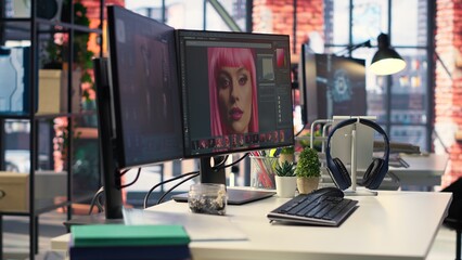 Modern office workspace equipped for digital design and photo editing. Screens show advanced...