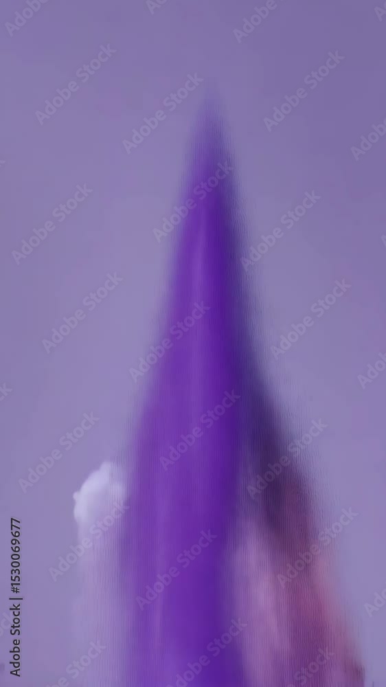 Poster abstract design with purple particles exploding against a soft cloudy backdrop with pastel pink hues