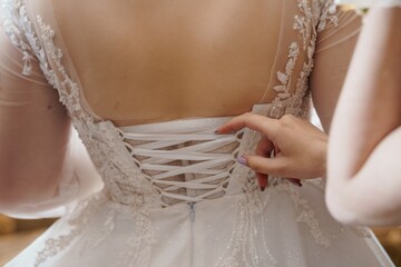 Wedding Dress Lacing Back Detail: Elegant Ivory Gown, Bride Getting Ready, Floral Appliques, Soft...