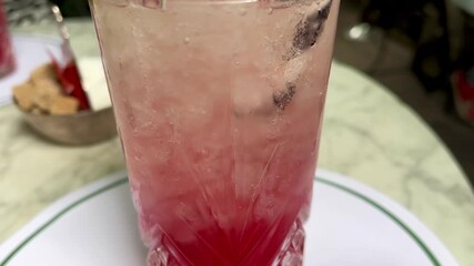 Chilled strawberry mojito with champagne sparkles, fresh mint garnish and crushed ice, served alfresco on a warm afternoon in London, slow motion - Powered by Adobe