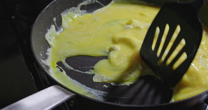 Making scrabbles eggs in a skillet at night 