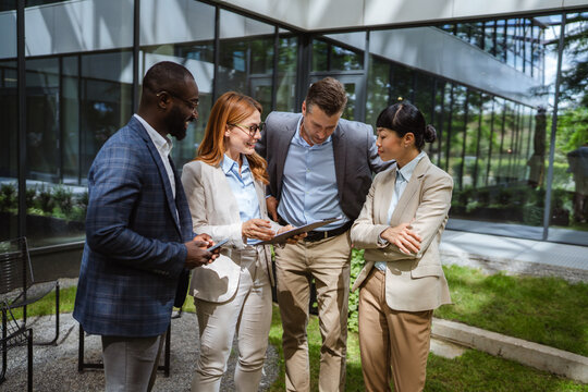 multiracial businesspeople review reports with business data charts