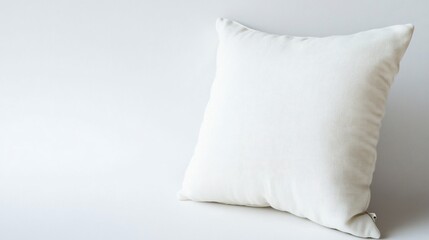 Soft textured white square cushion or pillow resting against white backdrop