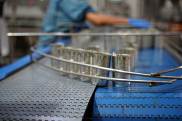 Cans moving on conveyor belt in a food processing facility during production hours