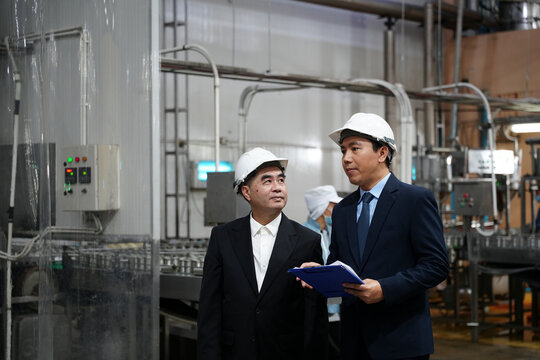 Executives discuss operations in a manufacturing facility during a business visit