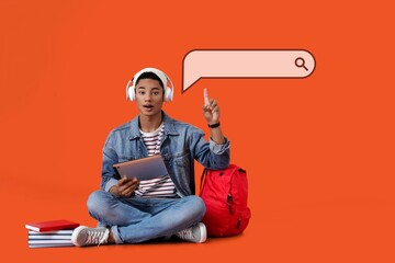 African-American student pointing at web search engine against orange background