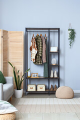 Interior of light room with shelving unit and clothes