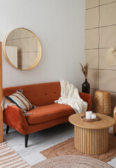 Interior of living room with brown sofa, mirror and coffee table