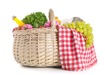 Wicker basket with tasty food for picnic, juice and peony flowers on white background
