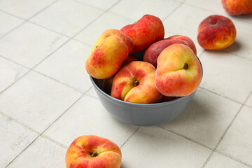 Bowl with sweet fig peaches on white tile background